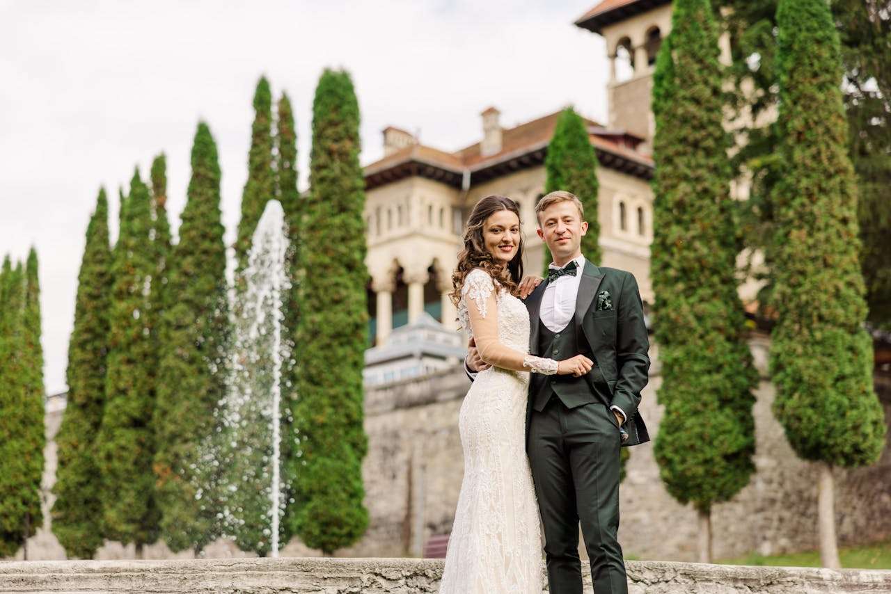 gallery-1 A newlywed couple poses in front of Bușteni's Cantacuzino Castle.