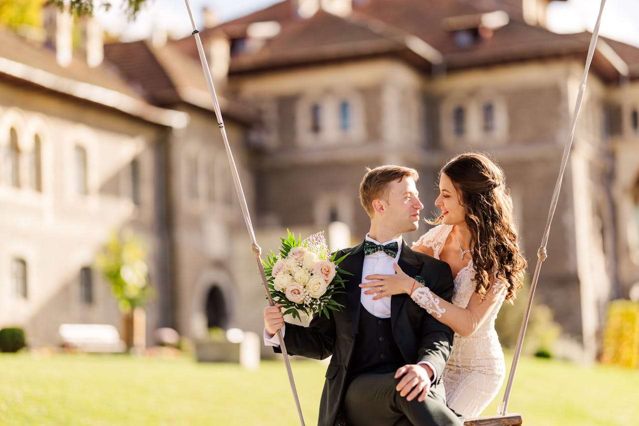 why-choose-us A newlywed couple enjoying a moment on a swing in a picturesque Romanian setting, capturing love and joy.